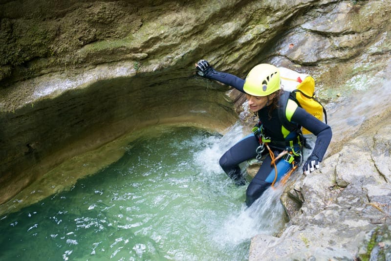 Actividades de verano Interlaken Parte 1 4 una persona con casco amarillo escalando una roca en la lata Canyoning Interlaken
