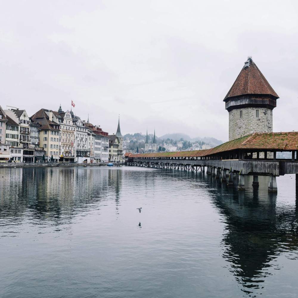 Pont de la Chapelle de Lucerne avec la tour de l'eau sur fond de ville suisse et ciel nuageux.